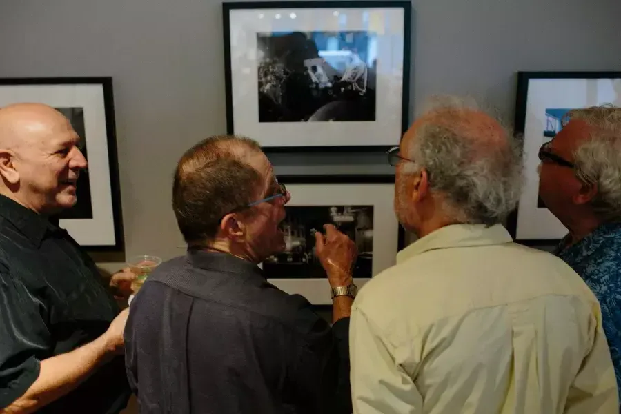Dennis McNally showing photographs to friends