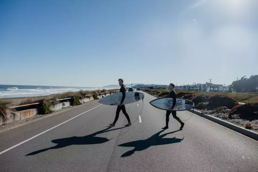 Nick Whittlesey holding a surfboard on the Great Highway.